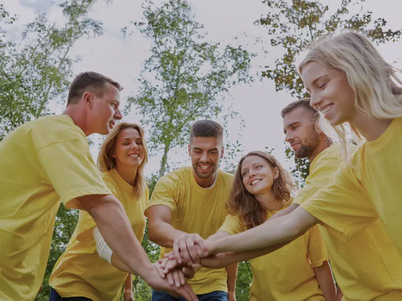 Tým hráčů v žlutých tričkách si podává ruce po úspěšném dokončení únikové hry během teambuildingu v Ostravě.